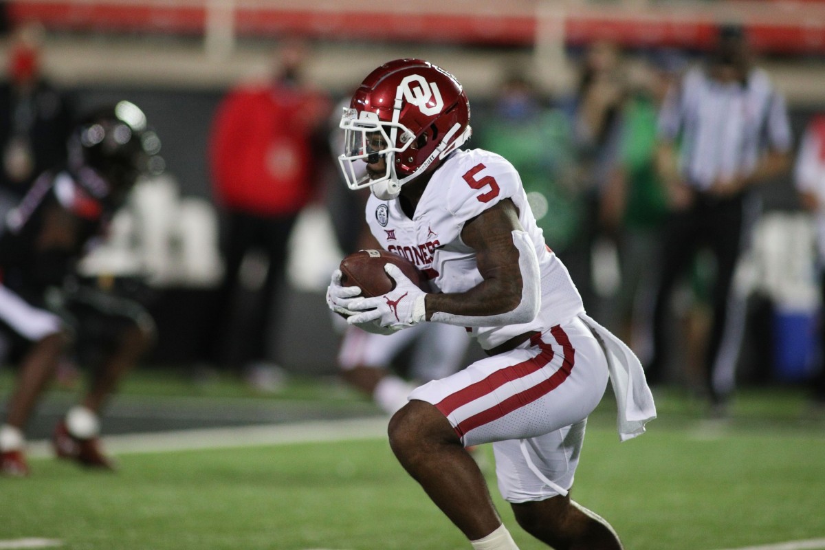 Oct 31, 2020; Lubbock, Texas, USA; Oklahoma Sooners running back TJ Pledger (5) rushes against the Texas Tech Red Raiders in the first half at Jones AT&T Stadium.